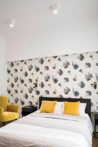 a bedroom with a white bed and a wall with wallpaper at Four Elements in Rome