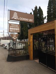 un cartello davanti a un cancello in un parcheggio di Gorski vrt a Novi Sad
