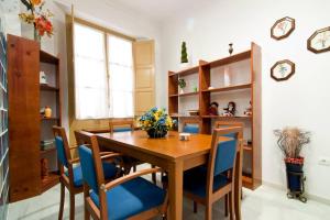 une salle à manger avec une table en bois et des chaises bleues dans l'établissement Apartamento Centro Historico, à Malaga