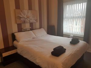 a bedroom with a bed with two hats on it at Langroyd Hotel in Blackpool