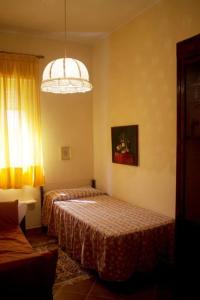 ノート・マリーナにあるVilla Adrianaのベッド2台とシャンデリアのある寝室