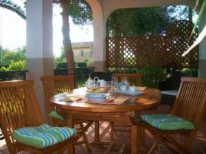 ノート・マリーナにあるVilla Adrianaのパティオにある木製のテーブルと椅子