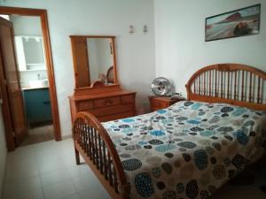 1 dormitorio con cama, tocador y espejo en Large beachfront apartment Medano, en El Médano