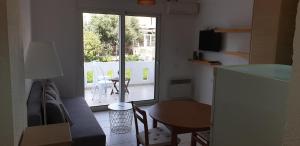 een woonkamer met een tafel en een keuken met een raam bij Studio Marevi in Elounda