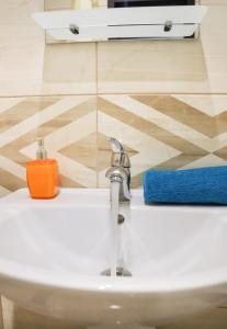 a bathroom sink with an orange soap sitting on it at Blue apartments on Kotsyubinsky Avenue in Vinnytsya