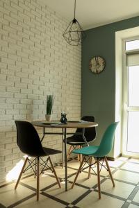 a dining room with a table and chairs and a clock at Blue apartments on Kotsyubinsky Avenue in Vinnytsya