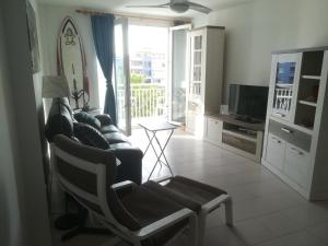 uma sala de estar com um sofá e uma televisão em Large beachfront apartment Medano em El Médano