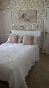 um quarto com uma cama branca e uma fotografia na parede em Nethermains House em Kilwinning