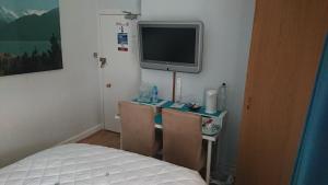 a bedroom with a desk with a tv and a bed at Nethermains House in Kilwinning