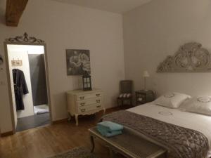 a bedroom with a bed and a dresser and a mirror at Le Chai de Villiers in Villiers
