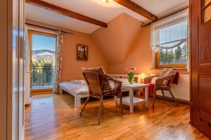 Cette chambre dispose d'une table, de chaises et d'un balcon. dans l'établissement U Dudy, à Kościelisko