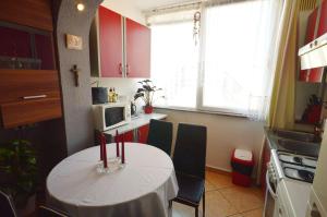 une petite cuisine avec une table et des chaises. dans l'établissement Apartment Živković, à Crikvenica