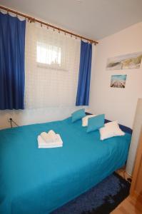 a blue bed with two towels on top of it at Apartment Živković in Crikvenica