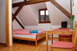 a room with a bed and a desk with a computer at Penzion u Vodopádu in Karlova Studánka