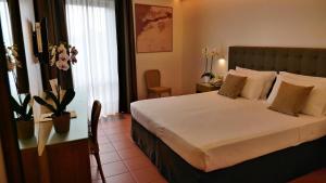 a bedroom with a large bed with white sheets and pillows at Rada Siri in Montepaone