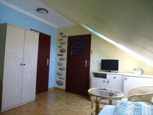 um quarto com uma cozinha com uma porta e uma televisão em Pokoje Pod Lasem em Stepnica