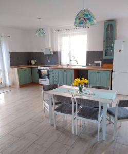 cocina con mesa, sillas y nevera en Rodzinny Apartament na Kaszubach, en Brusy