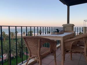d'un balcon avec une table et des chaises donnant sur l'océan. dans l'établissement Mirando al mar. Primera linea de playa, à Isla Canela