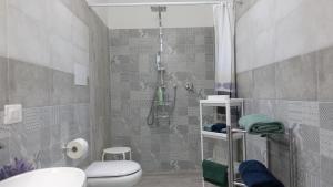 a bathroom with a shower and a toilet and a sink at Corte Risco in Ogliastro Cilento +28 photos