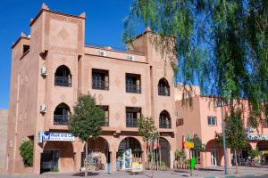 un gran edificio de ladrillo en una calle de la ciudad en Hotel Azoul, en Ouarzazate