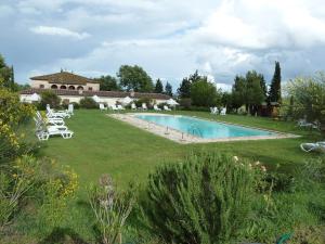 
a backyard with a pool and lawn chairs at Il Canto del Sole in Monteroni dʼArbia
