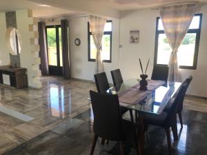 a dining room with a glass table and chairs at Villa Annjo in Pointe aux Piments