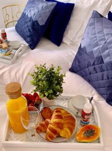 リスボンにあるApartments Alfacinha Ajudaのベッドの上に朝食用の食品のトレイ