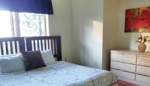 a bedroom with a bed with a dresser and a window at Vancouver WA Beautiful Apartment in Woodland