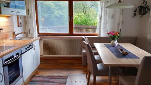 eine Küche mit einem Tisch und ein Esszimmer mit einem Fenster in der Unterkunft Ferienwohnungen Schweinöster in Lofer