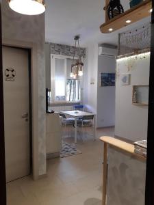 una cucina con tavolo e una porta in una stanza di casa vacanza sissi a Viareggio
