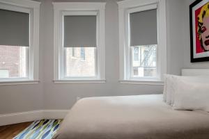 - une chambre blanche avec trois fenêtres et un lit dans l'établissement Modern Studio, 15 min Train to Boston #13, à Brookline