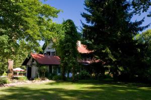 a house with a red roof in a yard with trees at Kietlice nad Mamrami in Węgorzewo +9 photos