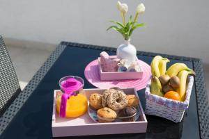 un tavolo con una scatola di frutta e un cesto di muffin di Apartments Braut Krk a Krk