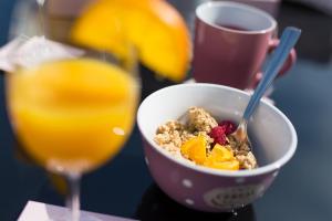 a bowl of cereal and fruit next to a glass of orange juice at Apartments Braut Krk in Krk