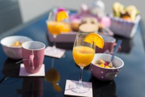 a table with two glasses of orange juice and a bowl of food at Apartments Braut Krk in Krk
