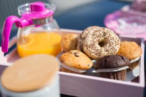 a box of donuts and muffins and a bottle of orange juice at Apartments Braut Krk in Krk