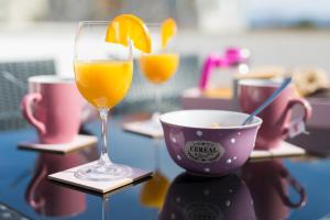 a glass of orange juice and a cup on a table at Apartments Braut Krk in Krk