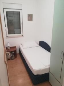 una piccola camera con un letto e una finestra di Apartman LOZA a Klek