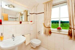 a bathroom with a sink and a toilet and a window at Ferienhaus Blütentraum in Binz auf Rügen in Binz