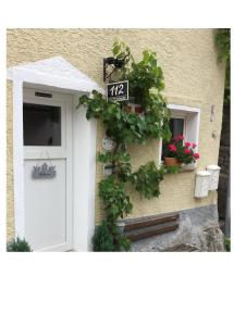 Una casa con una puerta con un cartel. en Burgweg Ferienwohnung, en Veringenstadt