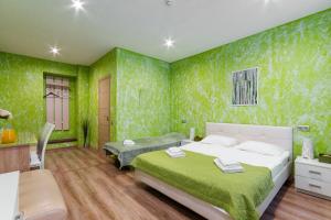 sypialnia z zielonymi ścianami, łóżkiem i biurkiem w obiekcie Mini Hotel Pomestie w Petersburgu
