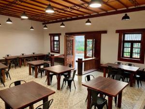 a restaurant with wooden tables and chairs in a room at Refugio de Santiago Ecolodge in Lunahuaná