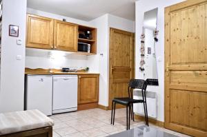 レ・デュー・アルプにある2 Alpes - Appartement Ski aux piedsのキッチン(白い家電製品、木製キャビネット付)