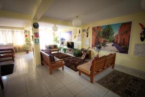 a living room with two benches in a room at Mama Backpackers in Lima