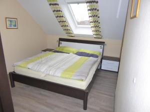 ノルトダイヒにあるCarmen u. Rudolf Lutzのベッドルーム1室(黄色いシーツ付きのベッド1台、窓付)