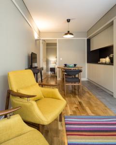 a living room with yellow chairs and a table at Porto Republica Apartments in Porto