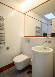 a white bathroom with a toilet and a sink at Porto Republica Apartments in Porto