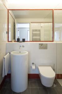 a bathroom with a sink and a toilet and a mirror at Porto Republica Apartments in Porto