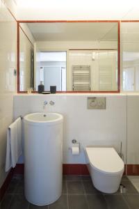 a bathroom with a sink and a toilet and a mirror at Porto Republica Apartments in Porto +51 photos