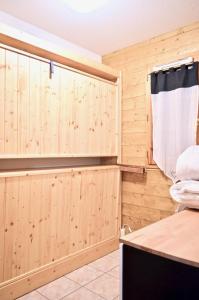 レ・デュー・アルプにある2 Alpes - Appartement Ski aux piedsの木製の壁、ベッド、窓が備わる客室です。